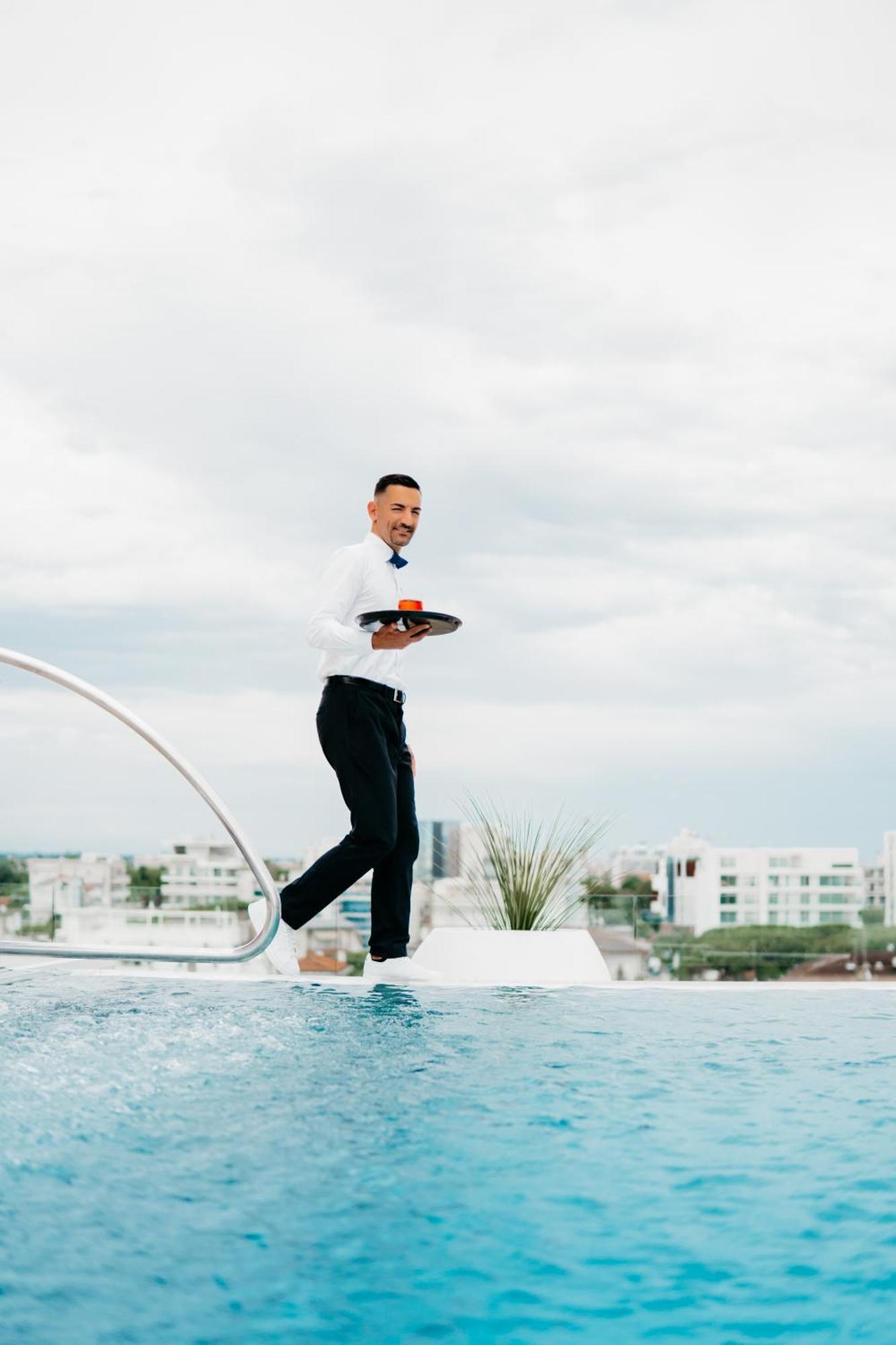 J44 Lifestyle Hotel Lido di Jesolo Bagian luar foto A waiter balancing on a tightrope