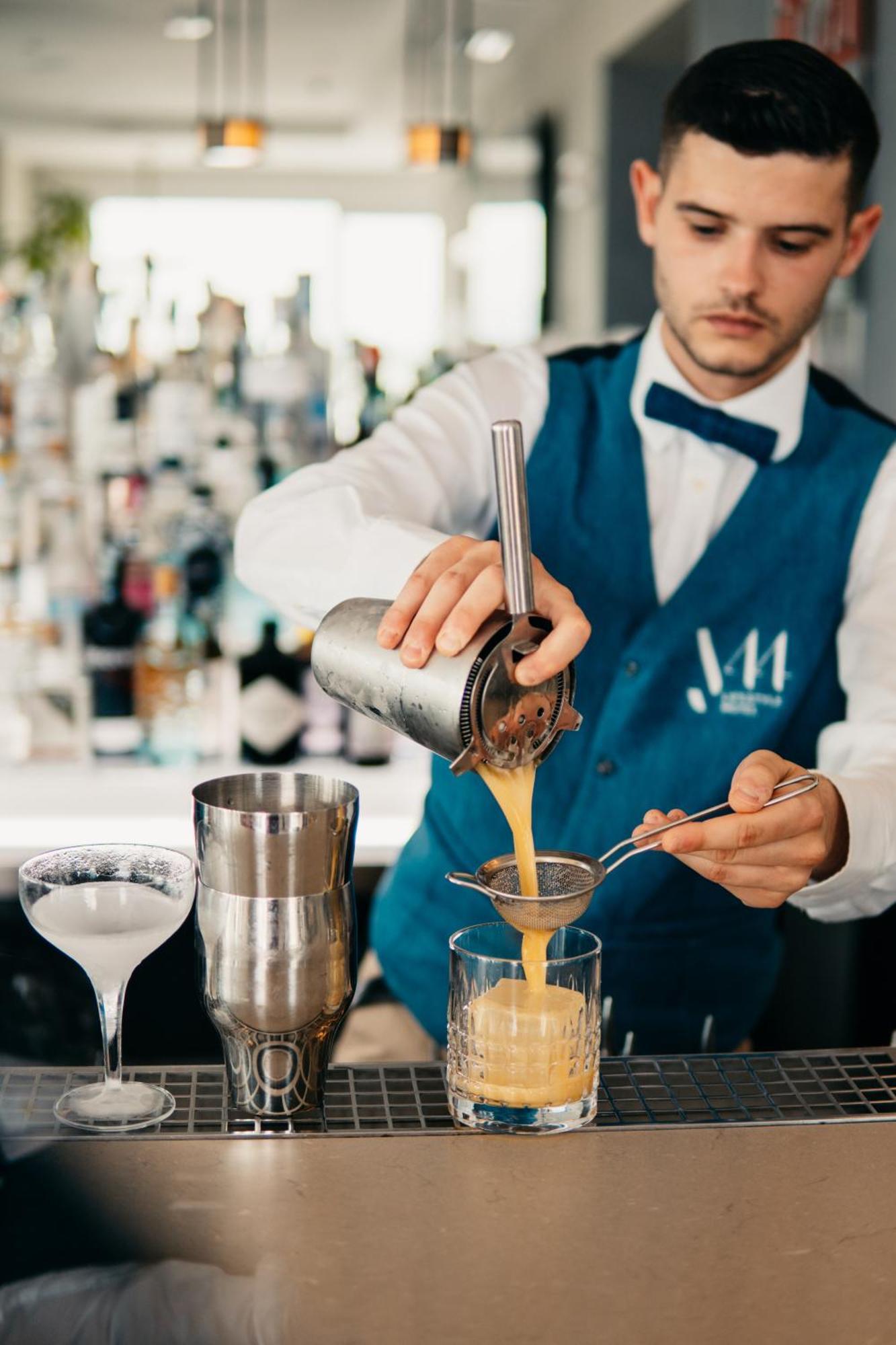 J44 Lifestyle Hotel Lido di Jesolo Bagian luar foto A bartender straining a cocktail